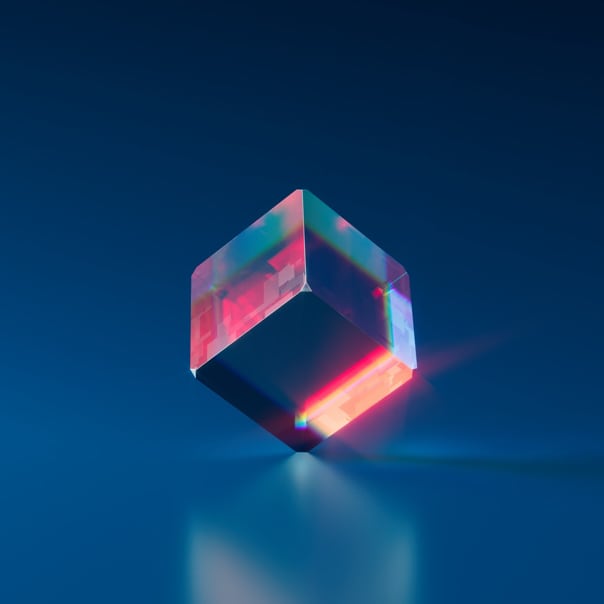 a reflective cube balanced on it's point on a blue background